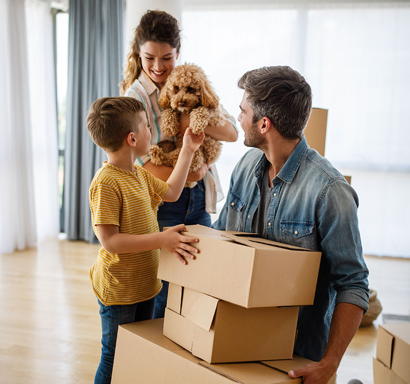Image showing a family of 3 with a dog and surrounded by boxes