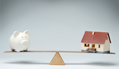 Image showing a model house and piggy bank balancing on a seesaw