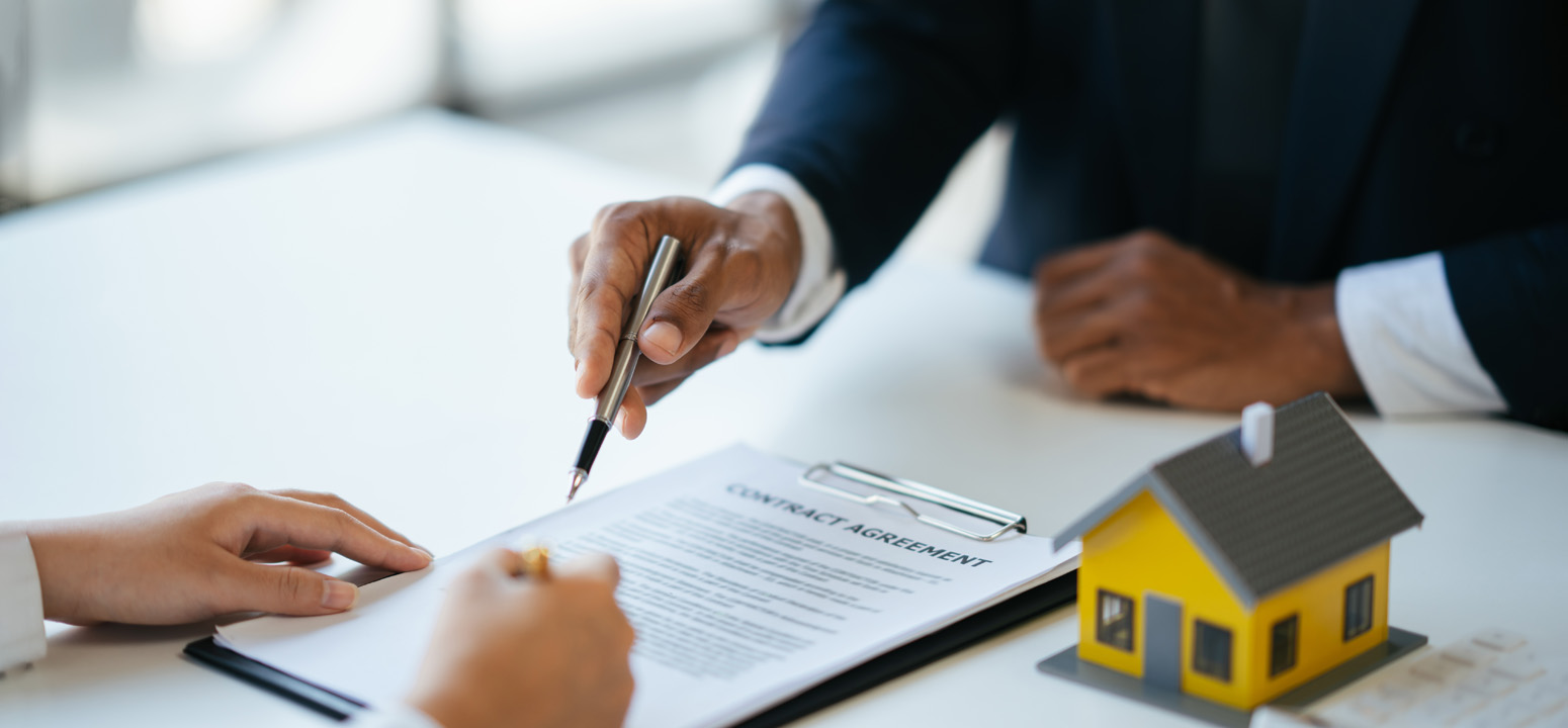 image showing hands with a pen and a tiny house