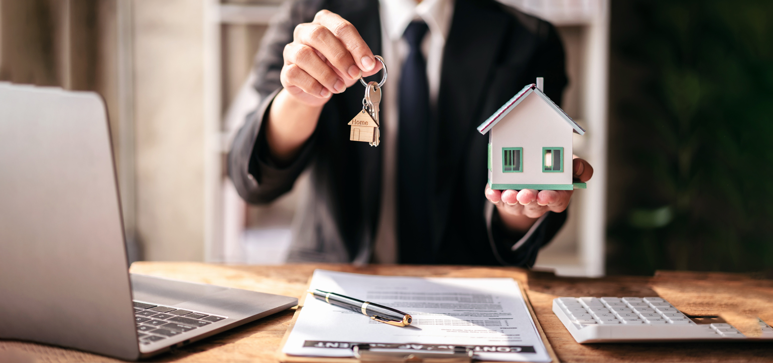 Image Showing a a man holding keys and wood houses in hand